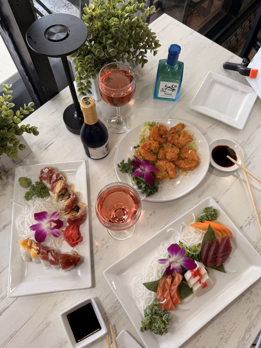 Happy hour table with rolls, sake and drinks at Sumo Sushi in Boca Raton